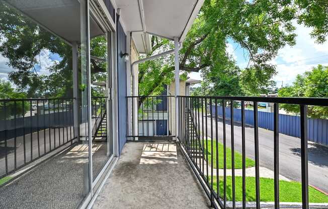 A balcony with a metal railing and a concrete floor.