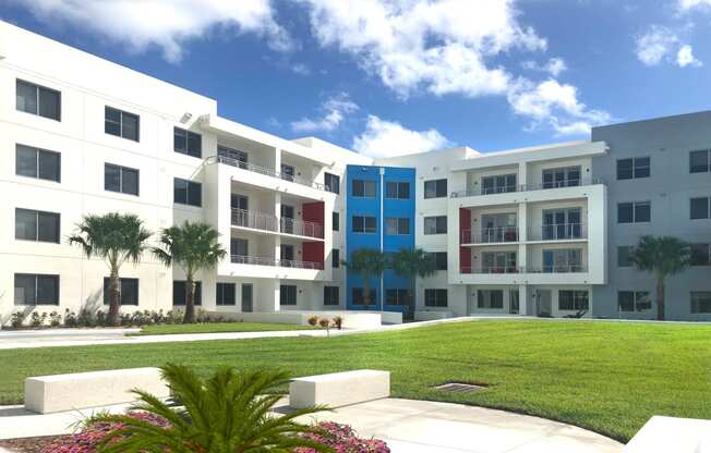 a building with a lawn and palm trees in front of it at Icon One, Daytona Beach, FL, 32114