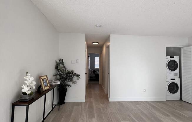 a living room with a wood floor and a washer and dryer in it at Campbell West Apartments, Campbell, 95008