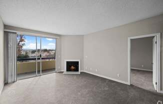 a living room with a fireplace and a balcony