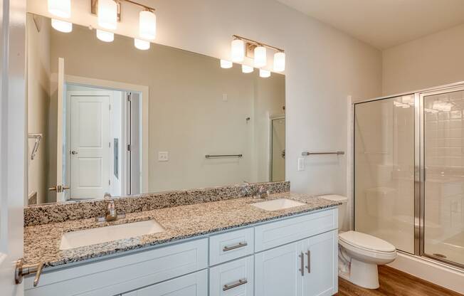 a bathroom with two sinks and a shower and a toilet at The Bella at Westchester, Virginia