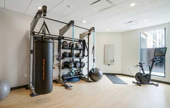 a 24-hour yoga & spin studio with a punching bag, pilates and yoga equipment, a bike, and an on-demand course mirror
