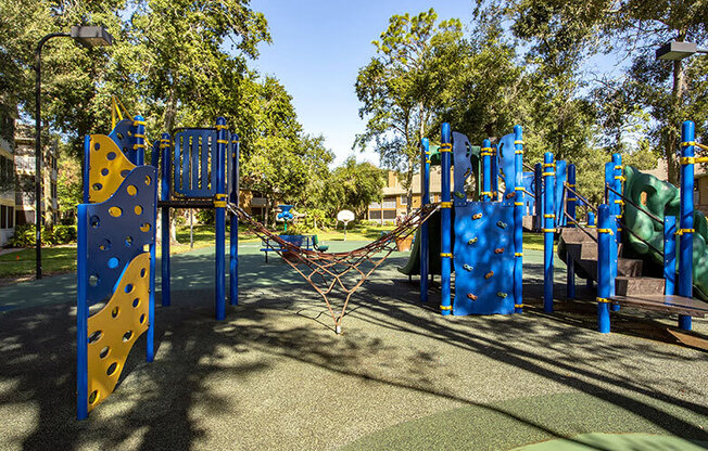 A playground with blue and yellow equipment.