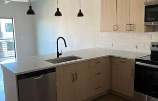 an empty kitchen with wooden cabinets and a sink