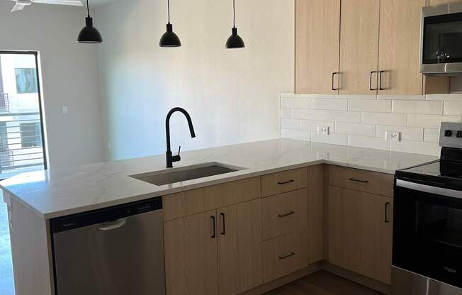 an empty kitchen with wooden cabinets and a sink