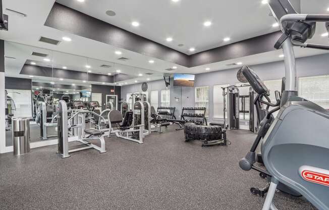 a gym with weights and cardio equipment at the enclave at university heights