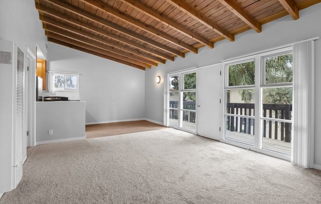 an empty living room with glass doors and a balcony