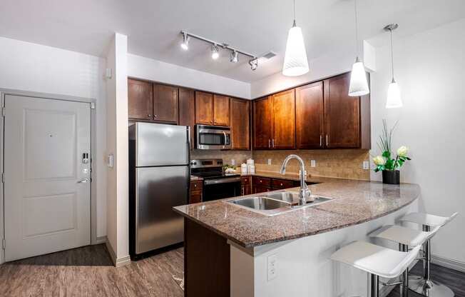 a kitchen with a granite counter top and a stainless steel refrigerator