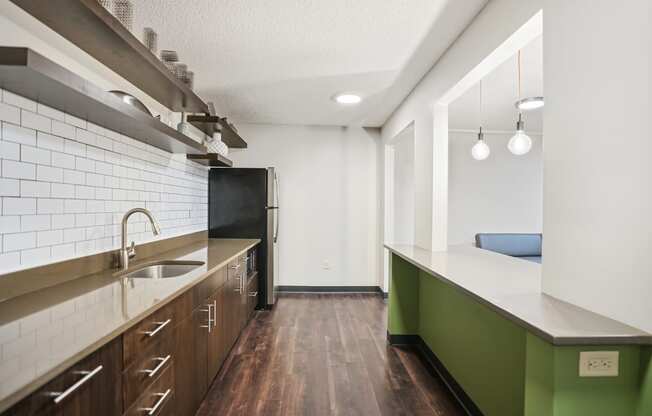 a kitchen with green cabinets and a sink and a refrigerator
