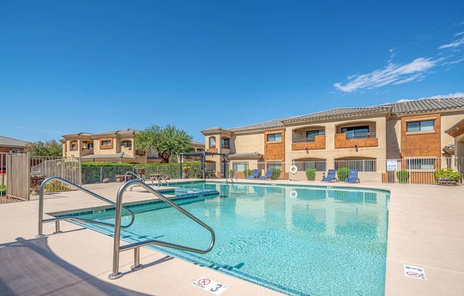 A swimming pool with a diving board in front of a building.