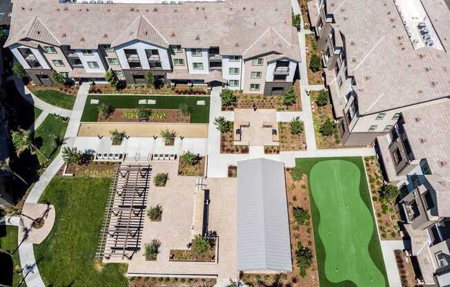 an aerial view of a house with a green lawn and a putting green