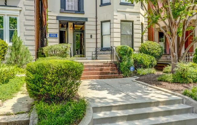 A house with a blue roof and a tree in front.
