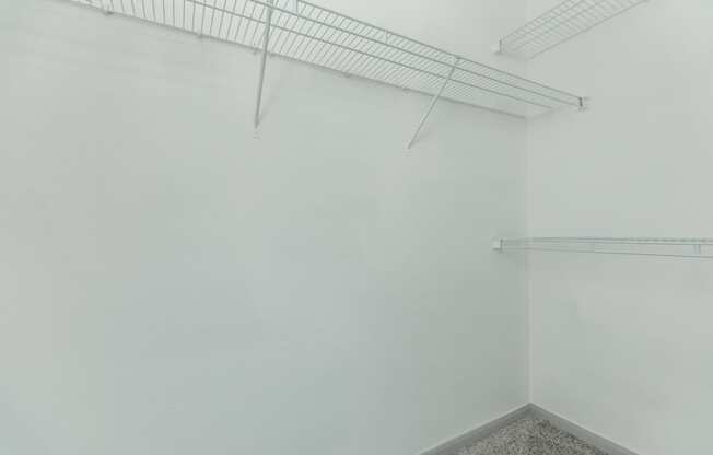 a room with white walls and a wire rack on the wall