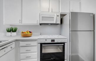a white kitchen with an oven and a refrigerator