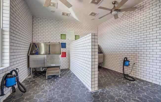 a white tiled bathroom with a stainless steel