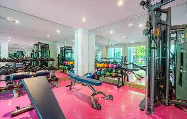 A gym with a pink floor and various exercise equipment.