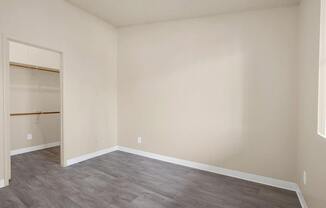 Empty room with grey flooring and white walls.