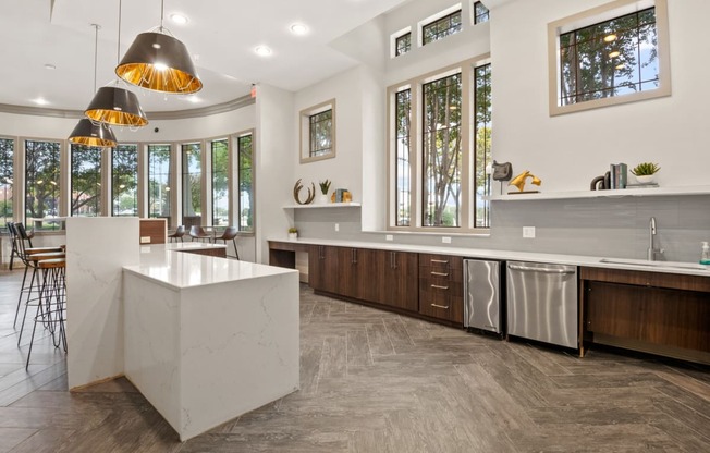 Community Kitchen with a large island and stainless steel appliances and large windows at Mission Gate, Texas, 75024