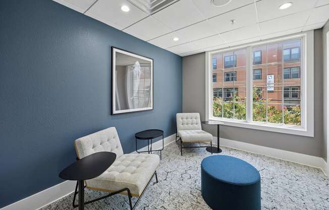 A room with blue walls and a window overlooking a building.