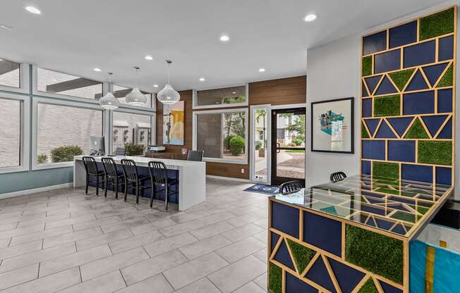 a lobby with a reception desk and chairs and a large window with a view of a courtyard