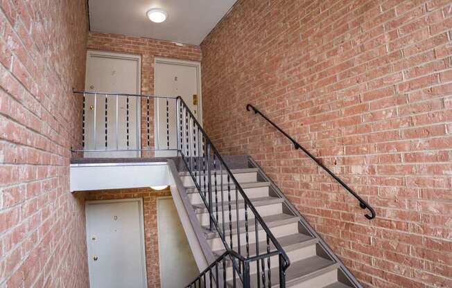 A staircase with a metal railing and a white door at the bottom.