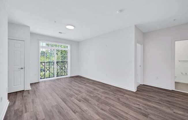 an empty living room with white walls and wood flooring