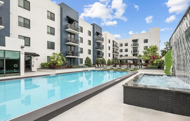 a swimming pool with an apartment building in the background