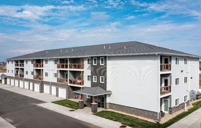 A large white building with a grey roof and a balcony on the second floor.