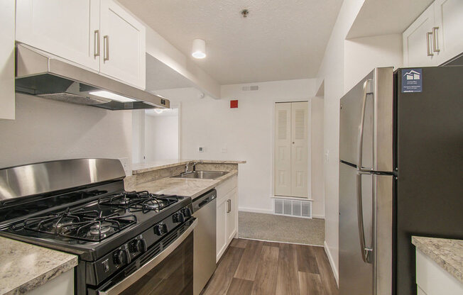a kitchen with stainless steel appliances and white cabinets at Canal 2 Apartments, Lansing, Michigan