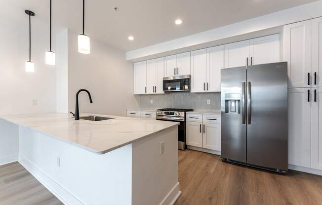 a large kitchen with white cabinets and stainless steel appliances