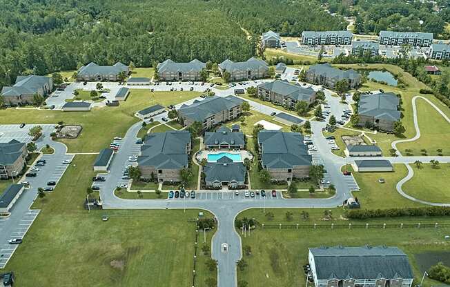 A bird's eye view of a residential area with houses and a swimming pool.