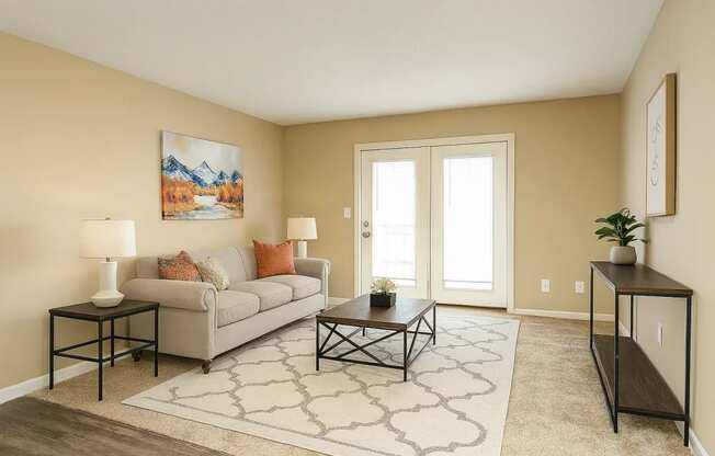 A living room with a grey couch, a coffee table, and a painting on the wall.