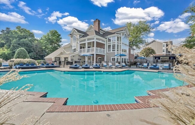 a large swimming pool with a house in the background