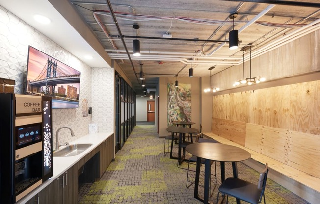 a communal area with tables and chairs and a coffee machine