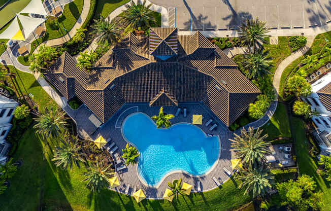 A large house with a pool in the middle of a grassy area.
