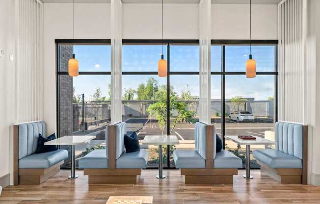 A modern cafe with blue chairs and tables.