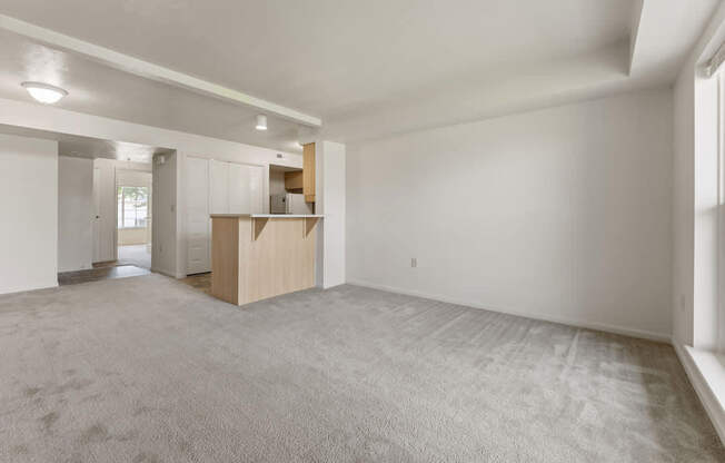 A large, empty living room with a carpeted floor at Stoney Pointe Apartment Homes, Wichita