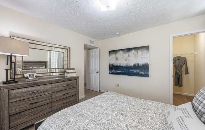 a bedroom with a bed and a dresser and a mirror