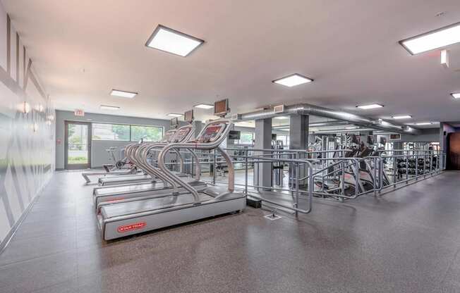 a large fitness room with cardio equipment