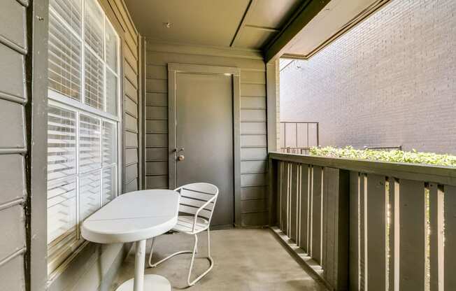 a balcony with a table and chairs and a door