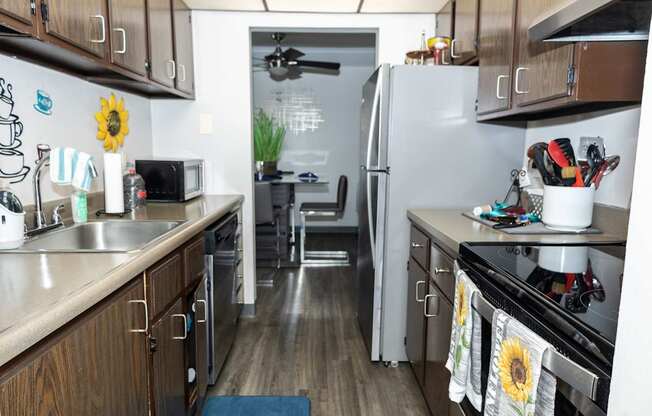 A kitchen with wooden cabinets and a stainless steel refrigerator.