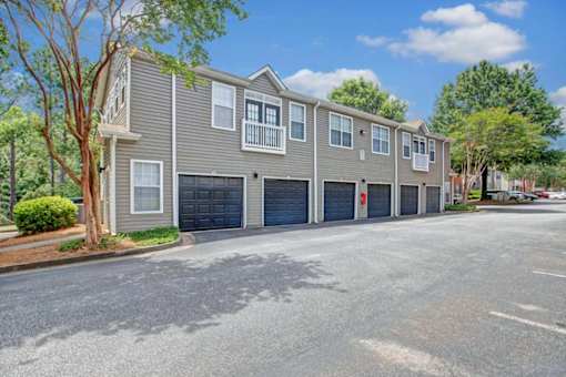 A row of townhouses with garages on the side.