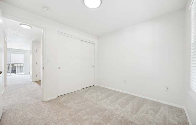 A white room with a carpeted floor and a door.