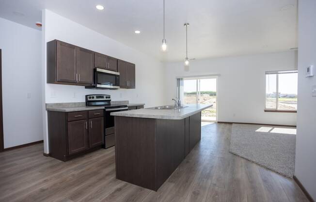 an empty kitchen with a large island in the middle