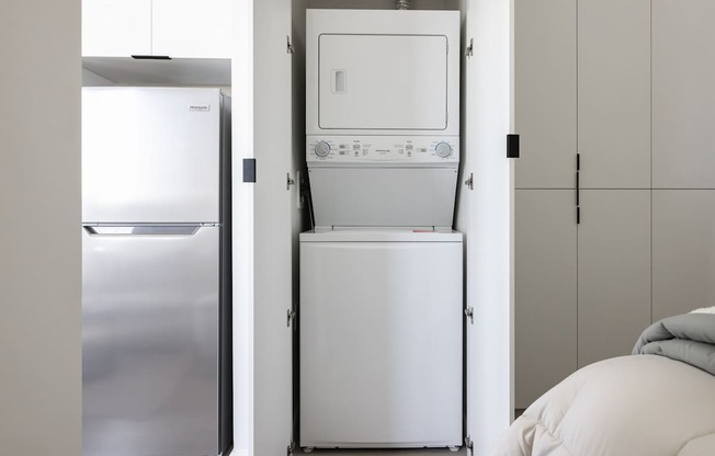 A white dishwasher is stacked on top of a white refrigerator at Skylar At Sunset Apartments, California, 90027