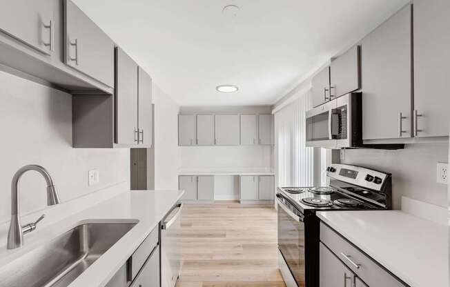A modern kitchen with stainless steel appliances and white cabinets.