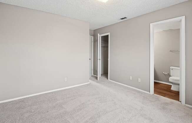 A room with a carpeted floor and a toilet in the corner.