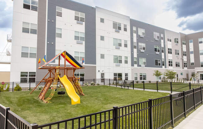 a playground in the middle of an apartment building with a slide