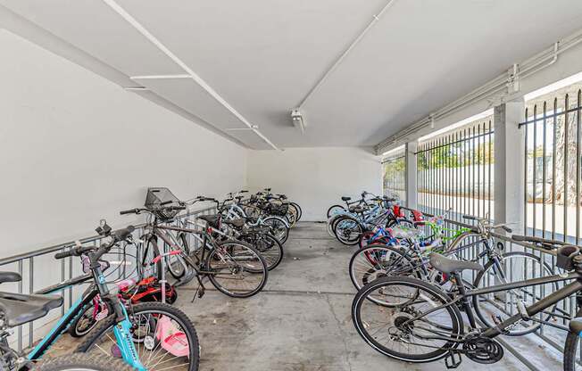 A bike rack full of bicycles in a white room.