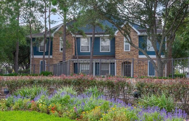 a close up of a flower garden in front of a house